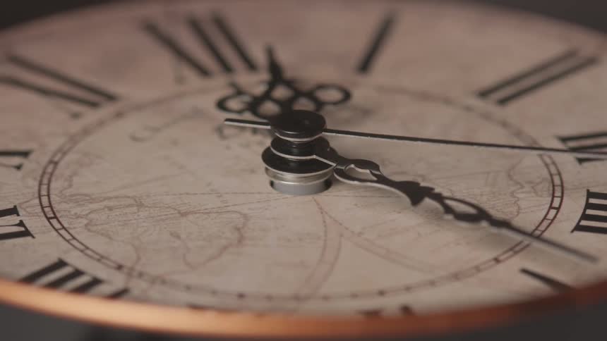 Close up of an analog clock with roman numerals in action