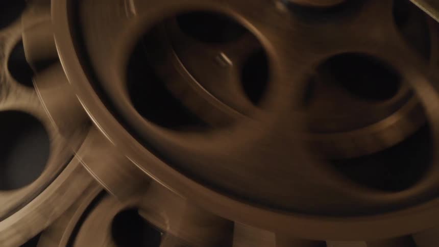 Closeup perspective of quickly turning gears and cogs of an antique clock mechanism