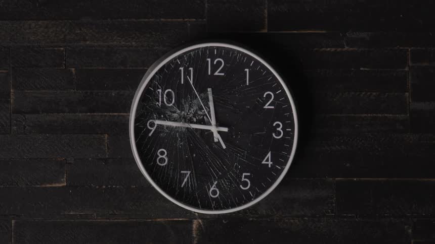 A wall clock with a broken glass face