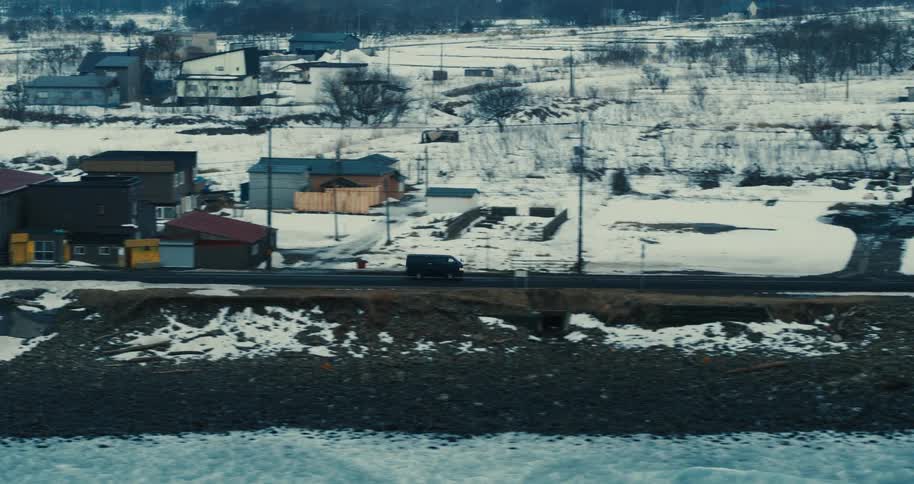 Snowcovered rural neighborhood with scattered houses and a nearby road