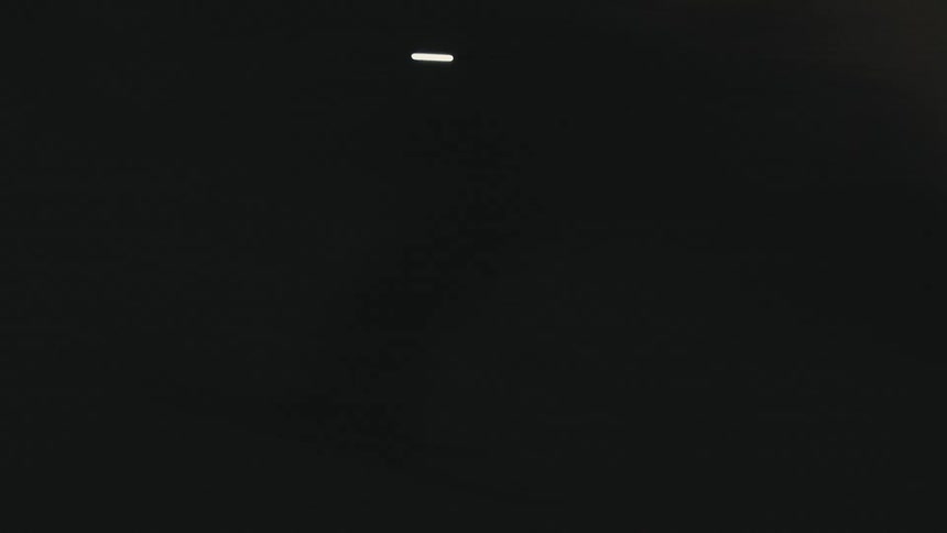 Silhouette of a person skiing in the snow with a flashlight