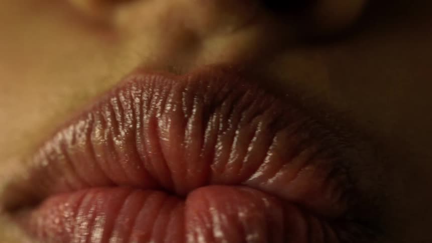Close up of a womans lips puckered up and moving from side to side