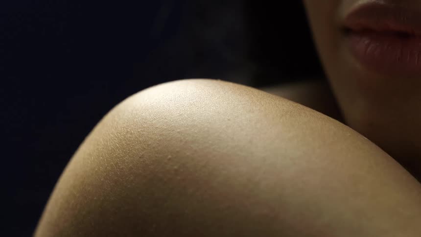 A black woman displaying the skin on her shoulder