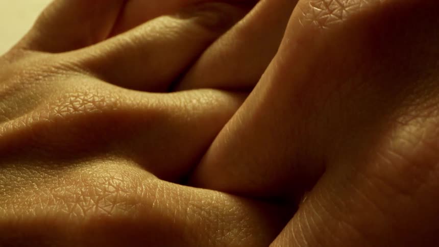 A person grips their fingers together