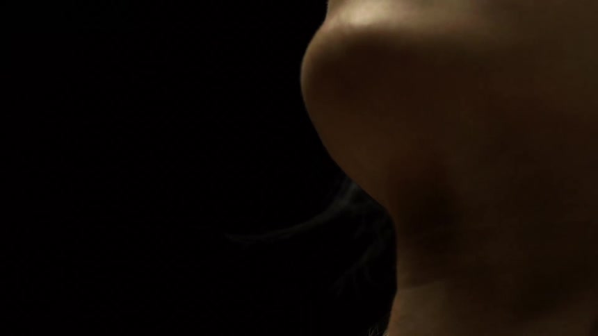 A woman turns her head in the dark