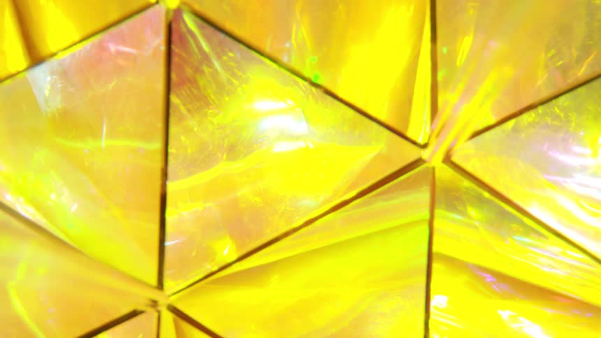 Close up of a glass crystal reflecting in yellow