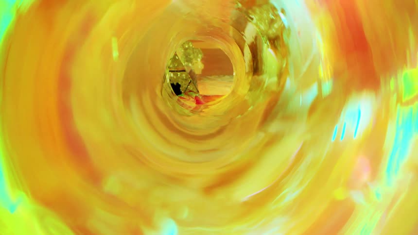 Close up of a colorful cylinder and a bright triangle in the background