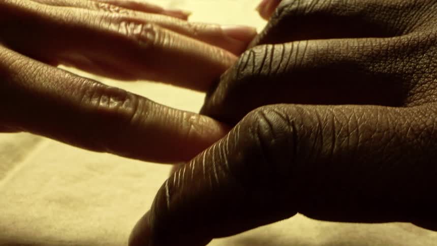 A man and woman are touching hands then they pull away