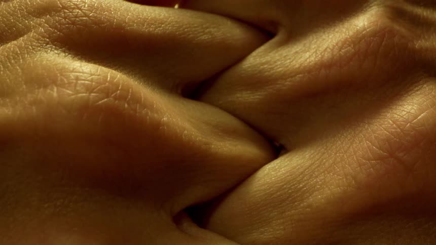 Close up of a persons hands as they interlock their fingers and knuckles and unlock them shortly after