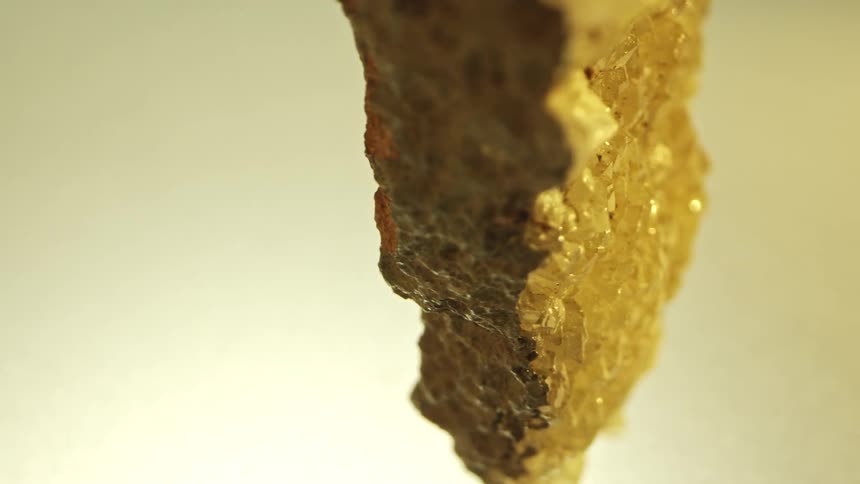Broken geode with yellow quartz crystals inside and rough rock outside