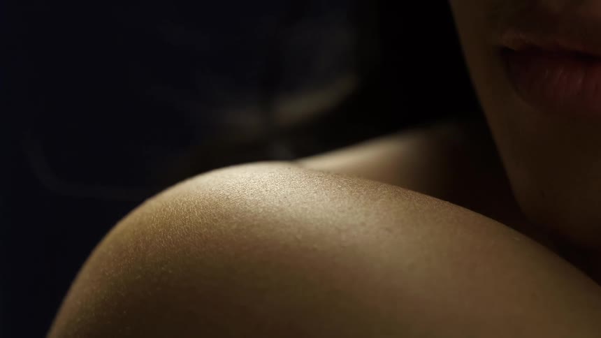 Light illuminates the smooth skin on a womans shouldner