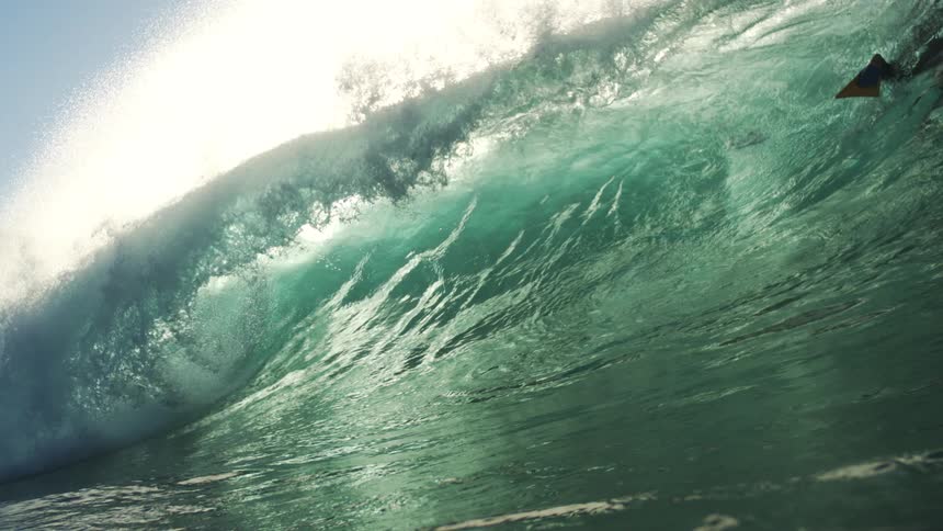 The surfer dives under the large crashing wave