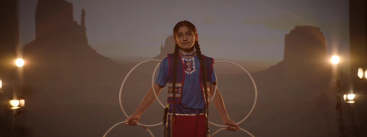 A girl is posing on stage in a tribal costume
