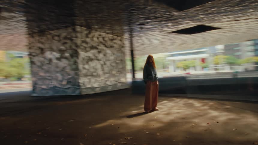 A woman is walking and looking at a building