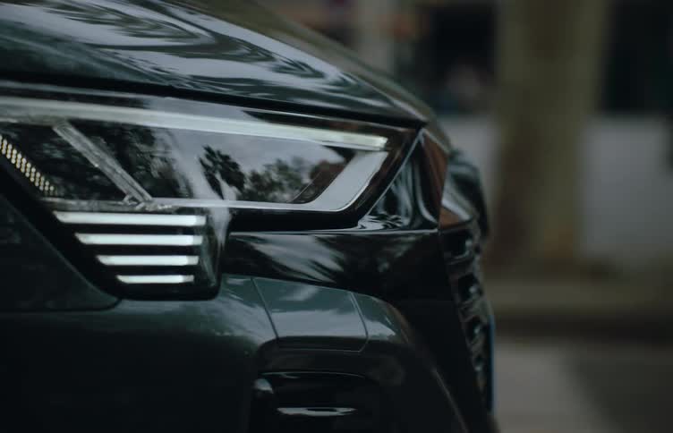Closeup of the headlights of a vehicle moving through the city