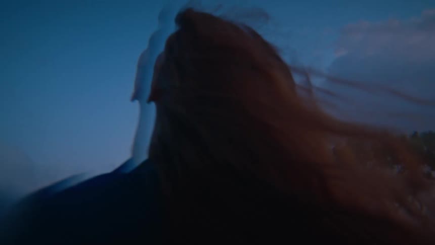 Digital effects distort and double the appearance of woman with long red hair