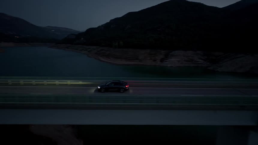 The car crosses the bridge at sunset