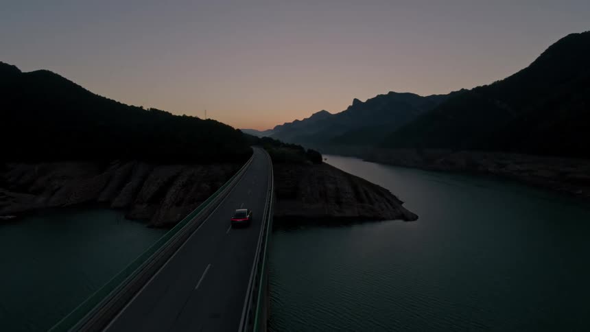 The car drives over the bridge on the islands at sunrise