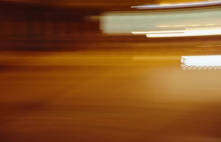 Traffic moves along a dark street at night