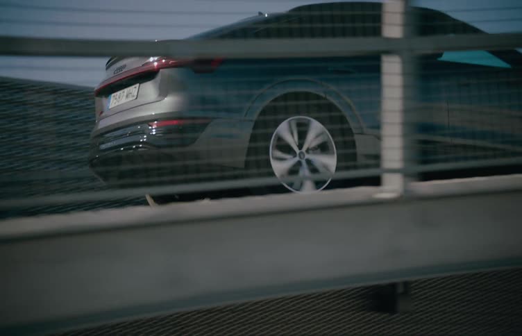 Car is driven outdoors up a metal slope with metal rails during daytime