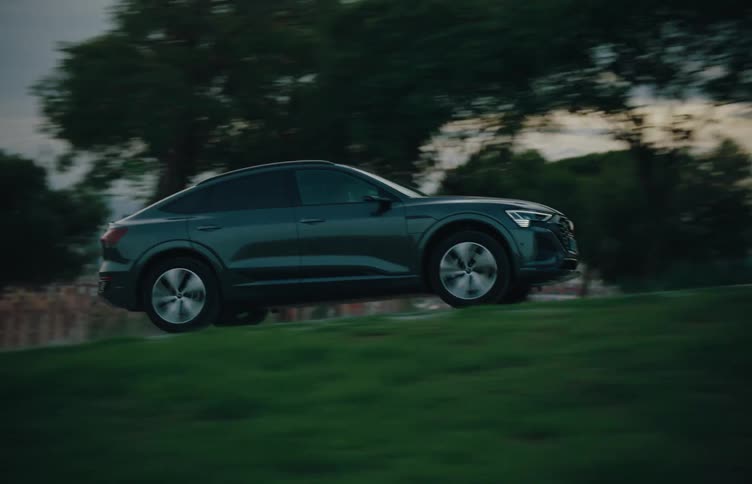 An audi etron sportback driving on a bumpy road at midday