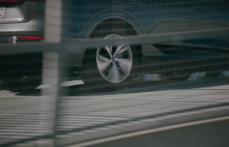 Close up of a car as it moves higher on a bridge in a city during the day