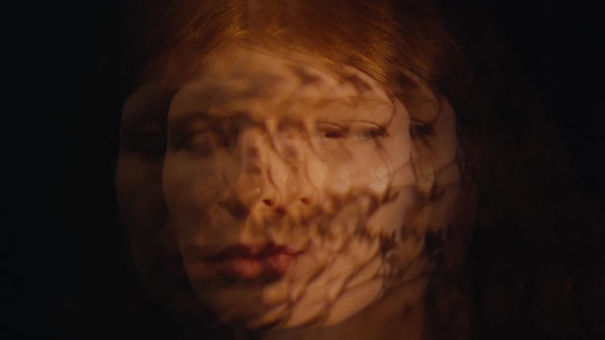 Portrait of a young woman in multiple exposures against a black background