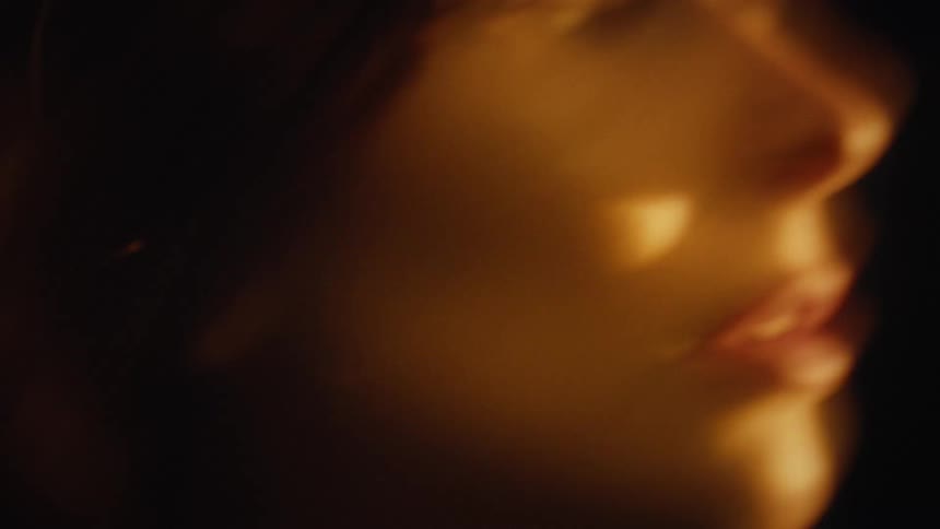 A young woman walks down the street at night