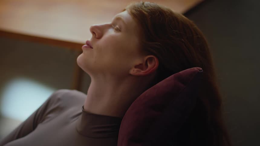 A woman is leaning her head on the pillow
