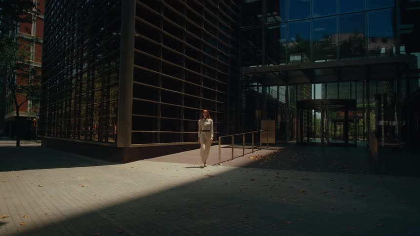 A woman walks form the entryway of the building