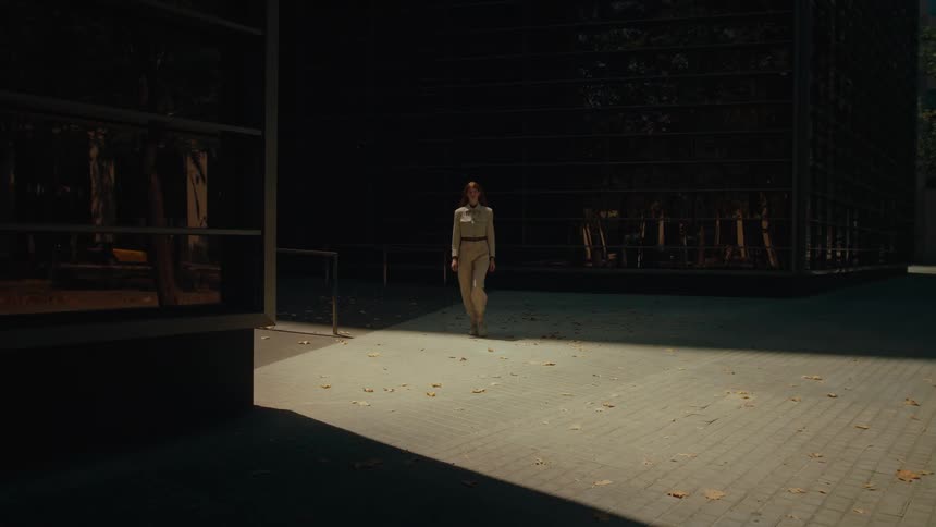 A woman walks from the large building