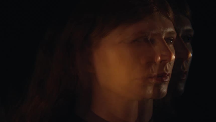 A woman turns her head in the dark