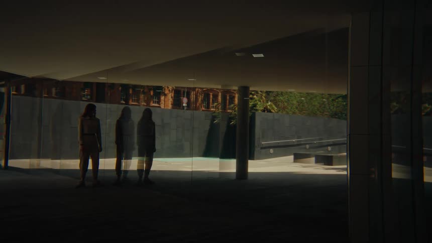 A woman looks into the large window on the building