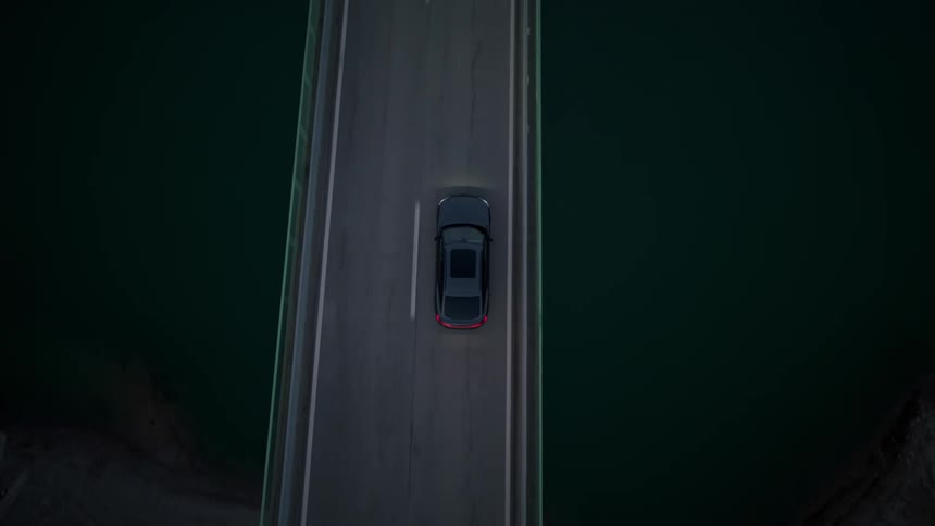 The car crosses the bridge towards the mountains