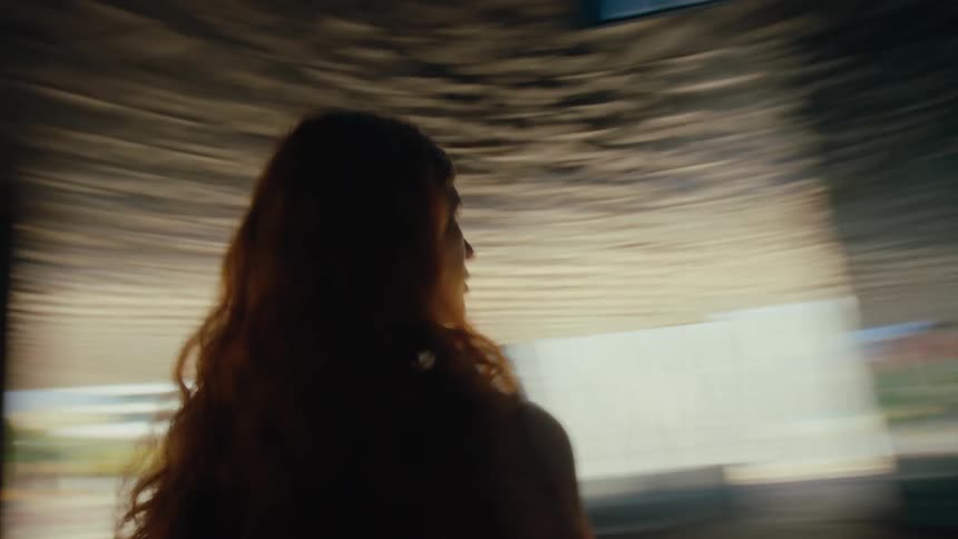 A woman is standing before the large windows on the building