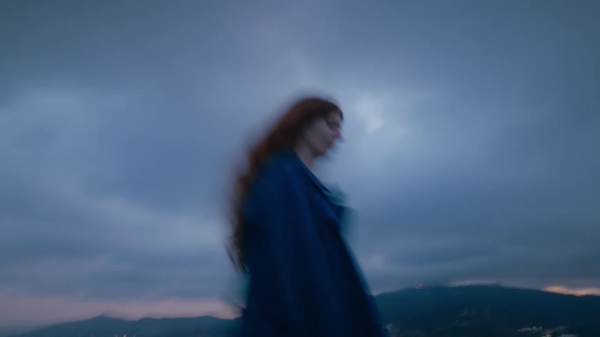 A woman looks around on a cloudy day