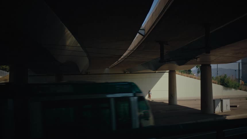 A cable train passes by a person standing under the overpass