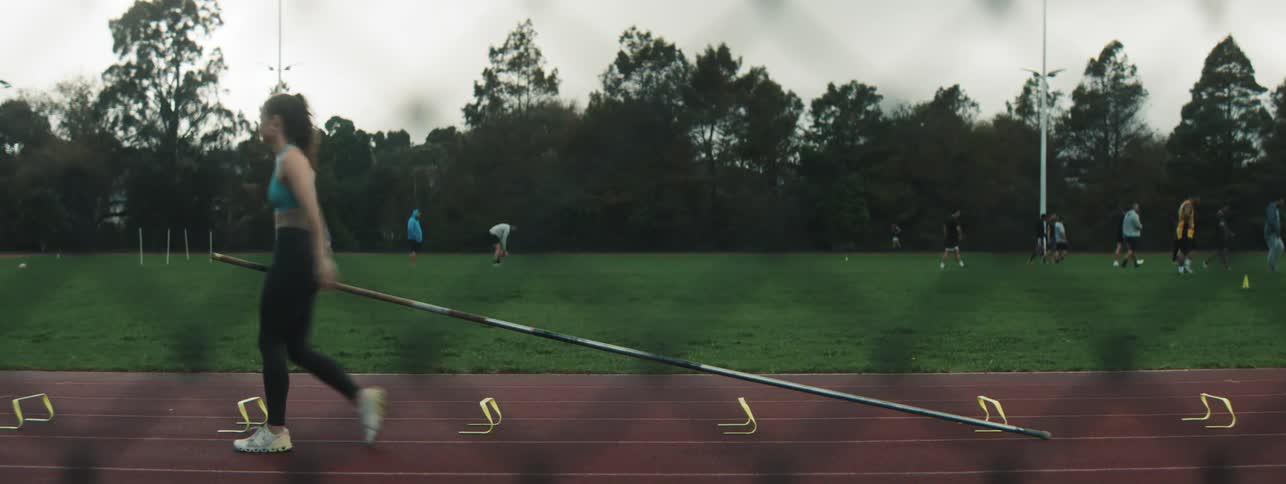 A woman is pole vaulting on the track