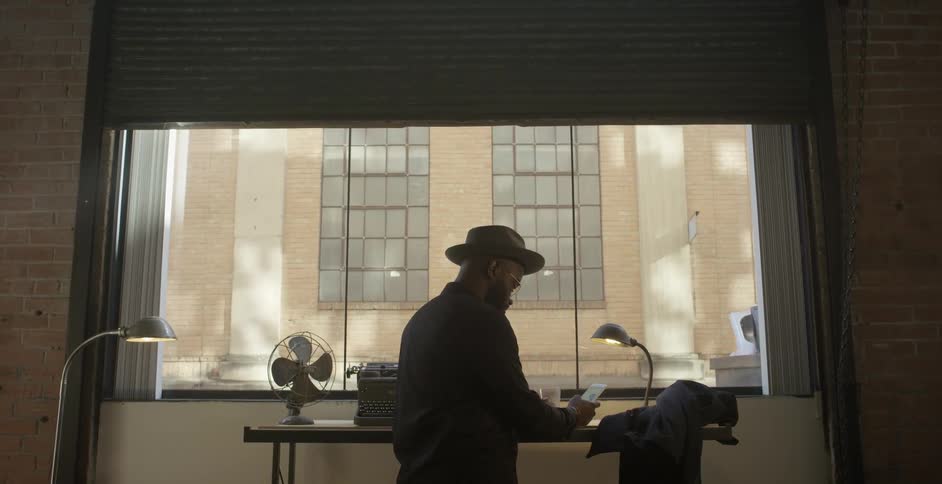 A man stands in front of an apartment window