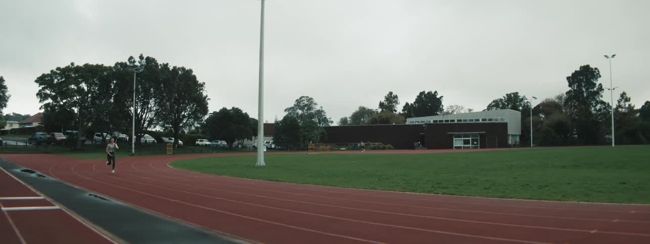 A female pole vaulter sprints on a track but misses planting their pole