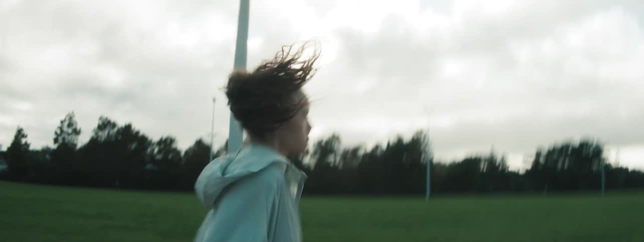 A female teen jogging on the race track at dawn