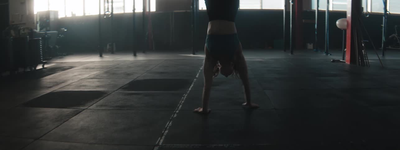 A woman does a walking handstand