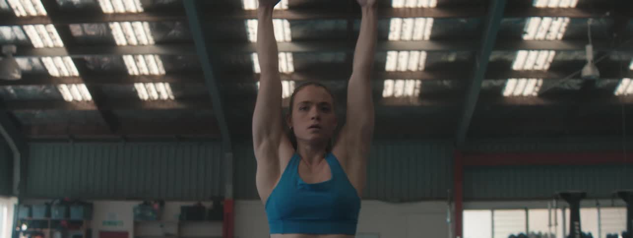 The gymnast jumps and hangs from the rings