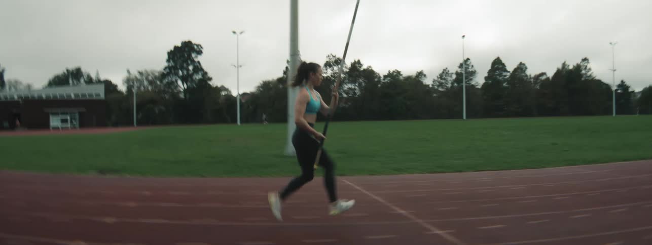 Woman on a running track training pole vault
