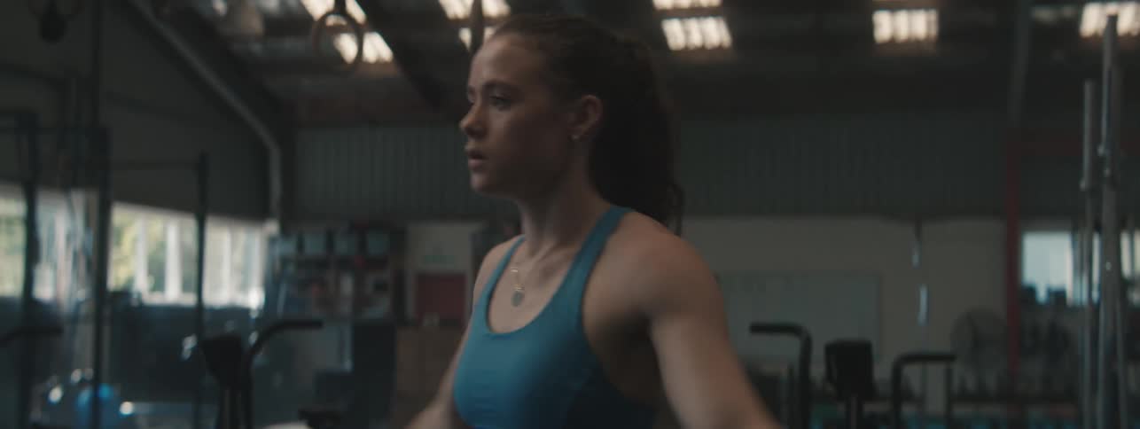 Woman stretches sidetoside in a gym