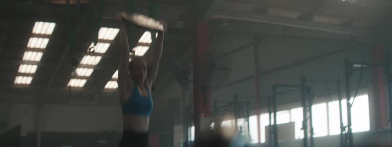 A woman runs and jumps with weights in her hands