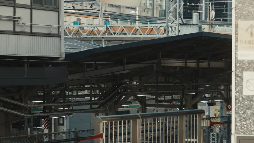A series of trains pass by a train station at midday