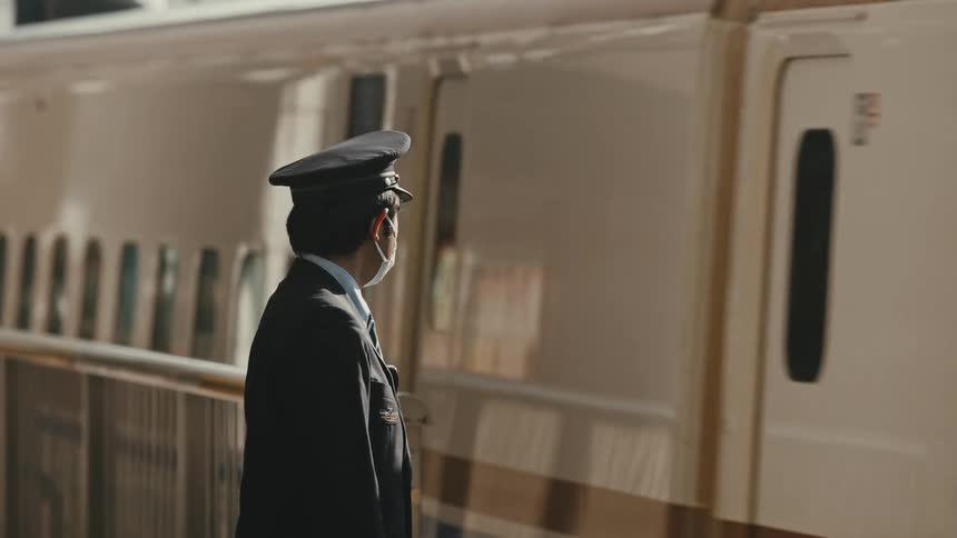 A worker watches the train pass by