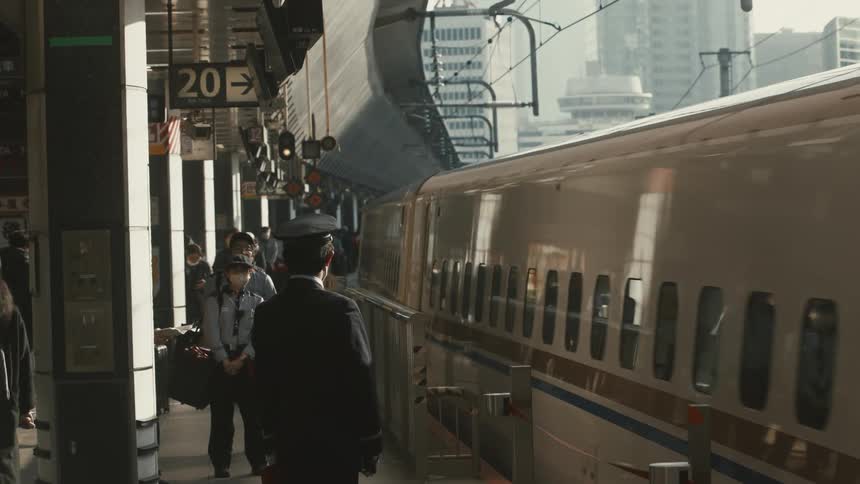 People wear face masks while waiting for the train at a station in the city