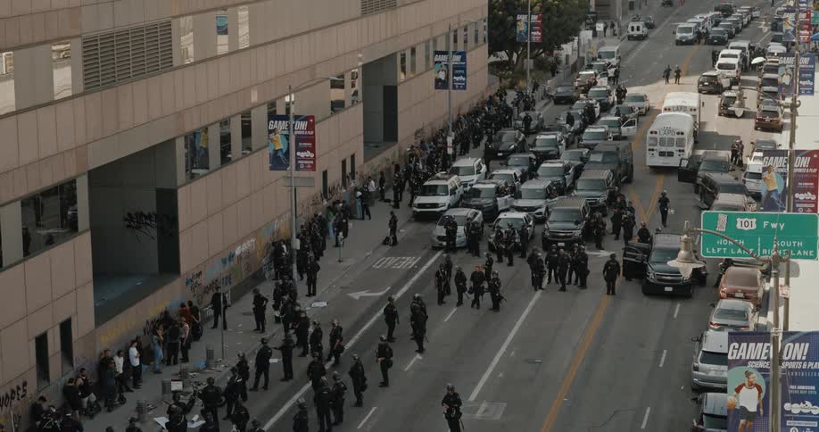 Police force containing protesters on an urban road